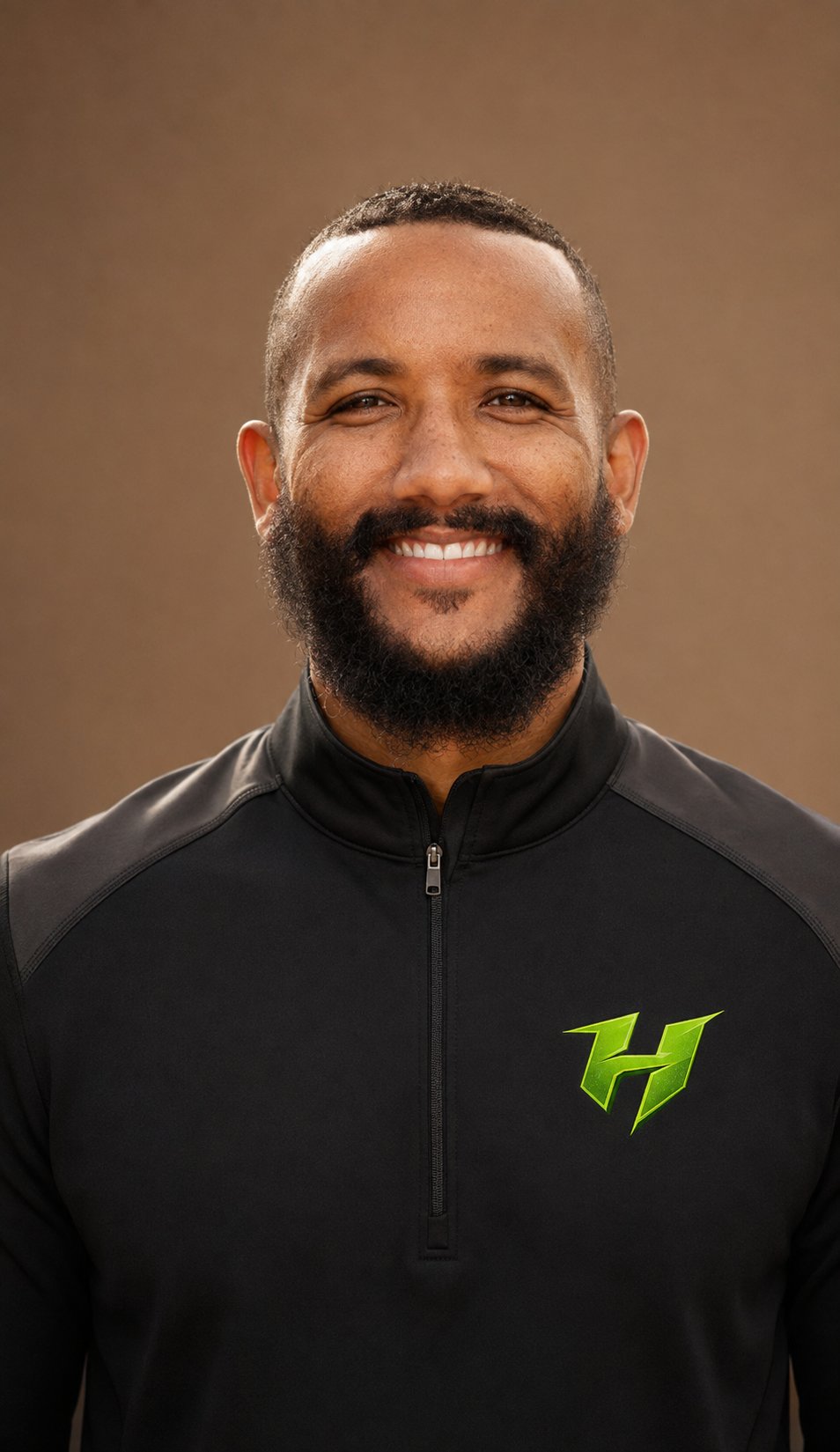 Trey Pringle, Director of Operations for The Huddle Inc., smiling in a black zip-up jacket with The Huddle logo